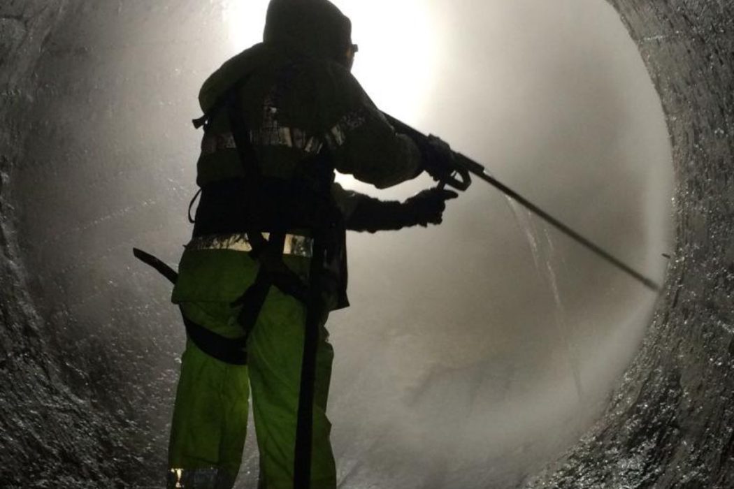 Rescue worker using water hose inside tunnel